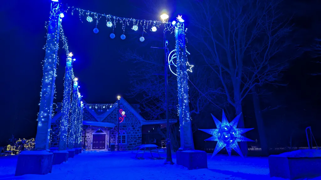 Décor extérieur hivernal illuminé de guirlandes bleues et d'une étoile lumineuse — Église Trinity, Iberville (2025).